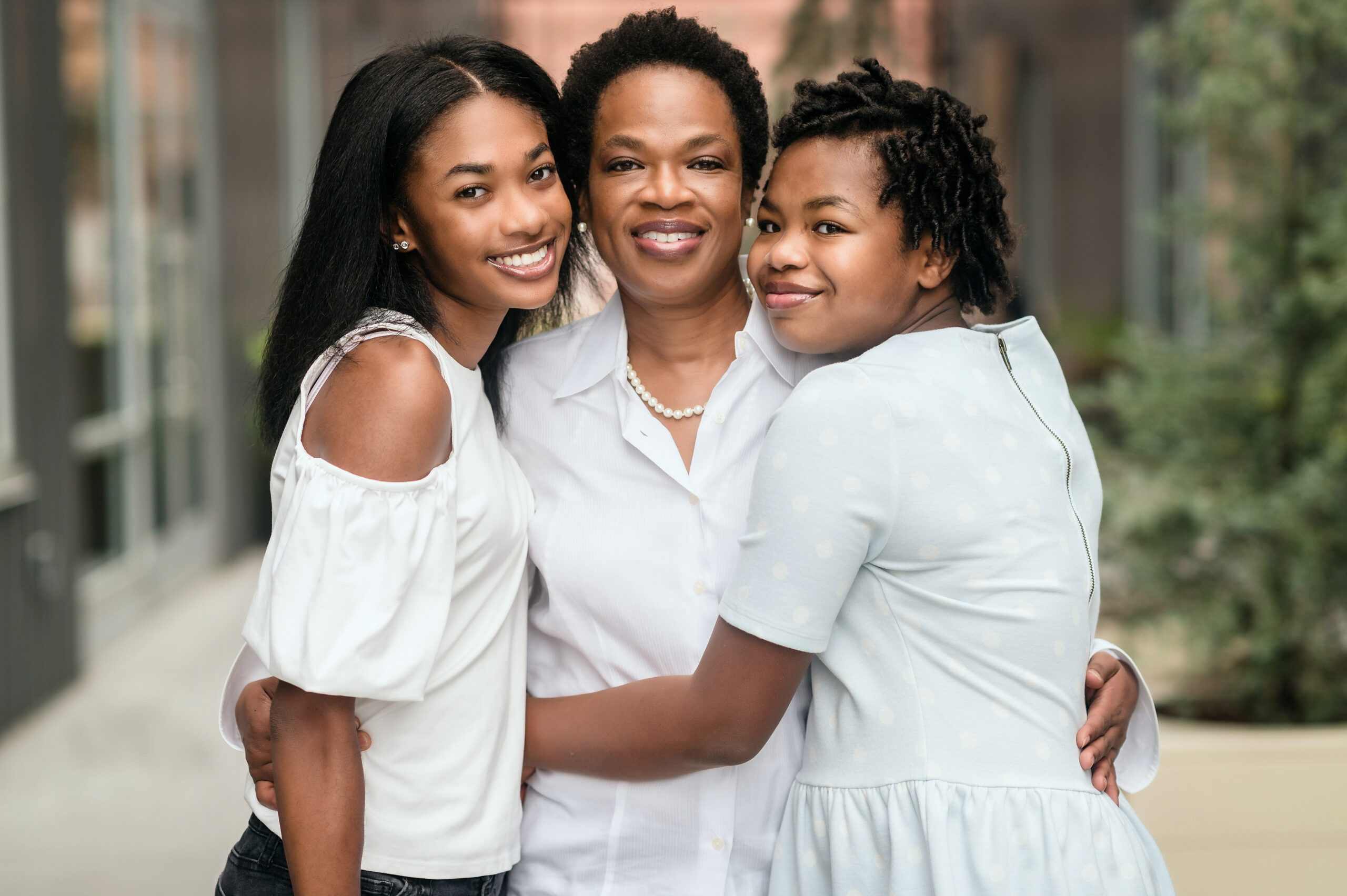 A mother embracing her two daughters at a family photo session